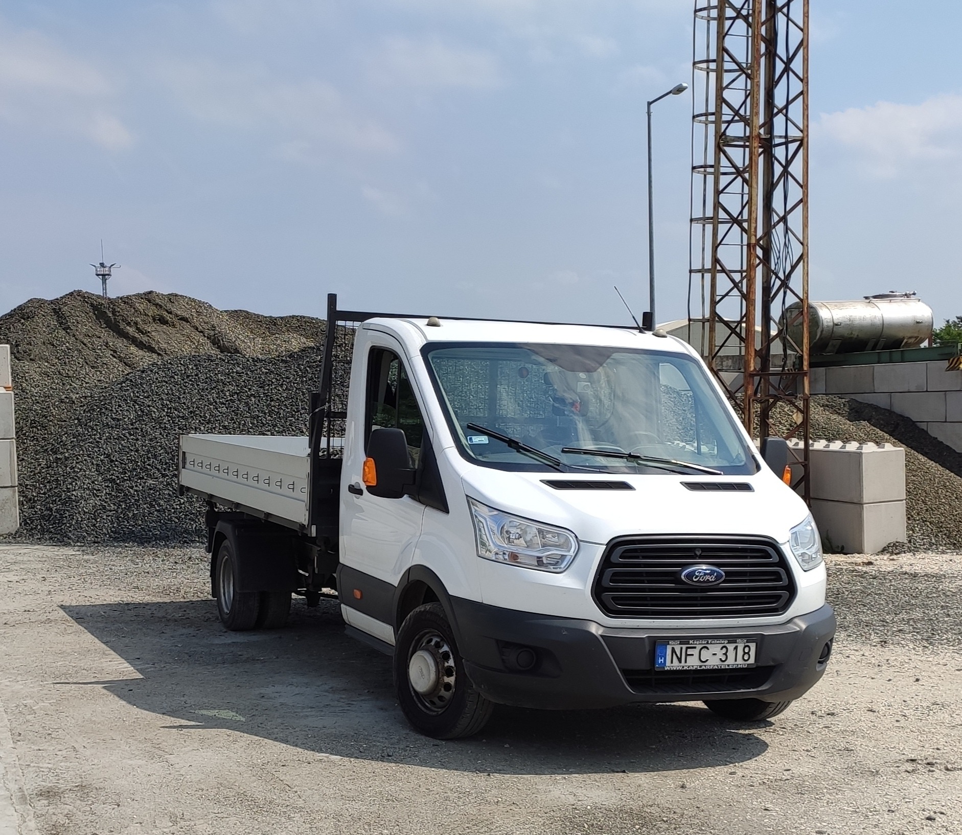 A fehér Ford Transit ponyva nélküli billenőplatóval, sóderes telepen